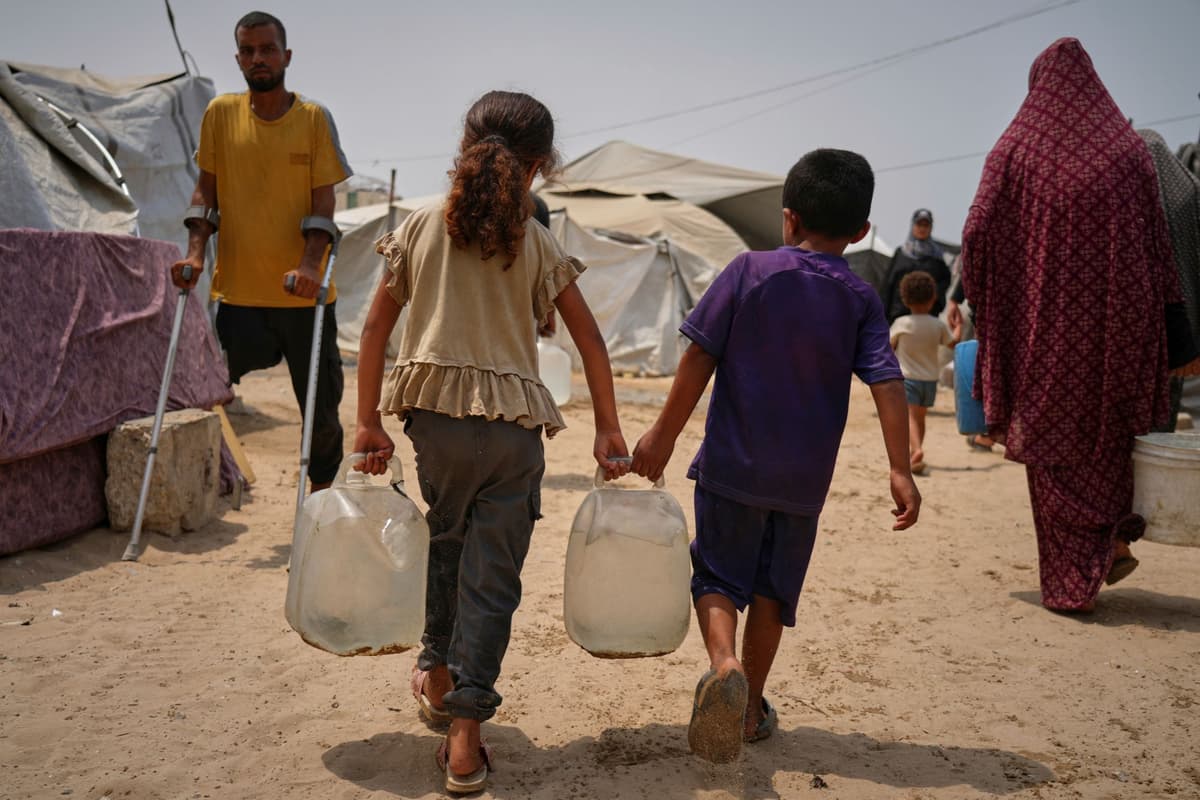 Palestínske deti nesú kanistre s vodou počas letných horúčav v distribučnom centre v meste Gaza 12. augusta 2025. Foto: TASR/AP