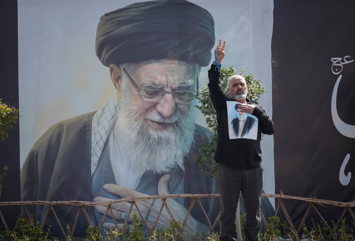 Iránec ukazuje znak víťazstva stojac pred portrétom zabitého vodcu ajatolláha Alího Chameneího v Teheráne 4. marca. Foto: Morteza Nikoubazl/ NurPhoto / Shutterstock Editorial / Profimedia