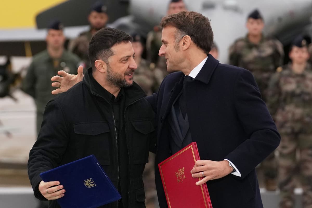 Emmanuel Macron a Volodymyr Zelenskyj sa objímajú po podpise dohody o nákupe stíhačiek Rafale počas ich stretnutia na leteckej základni Villacoublay 17. novembra 2025. Foto: TASR/AP
