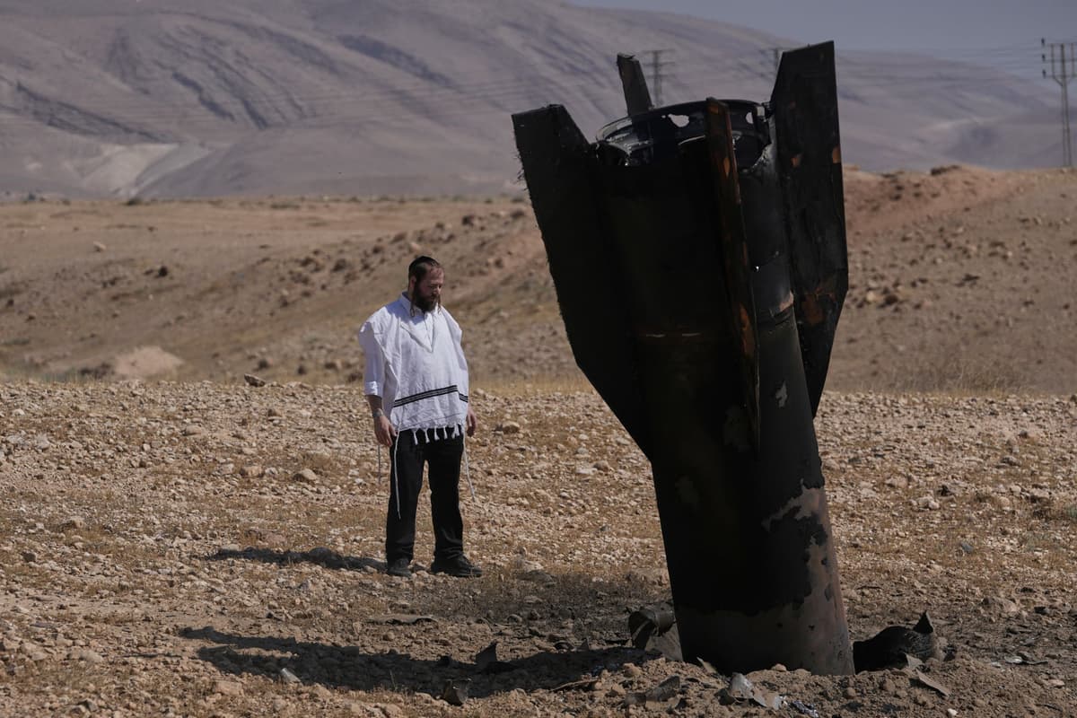 Muž si prezerá trosky iránskej rakety, ktorá dopadla v pondelok 8. júna 2026 v blízkosti mesta Jericho na Západnom brehu. Foto: TASR/AP
