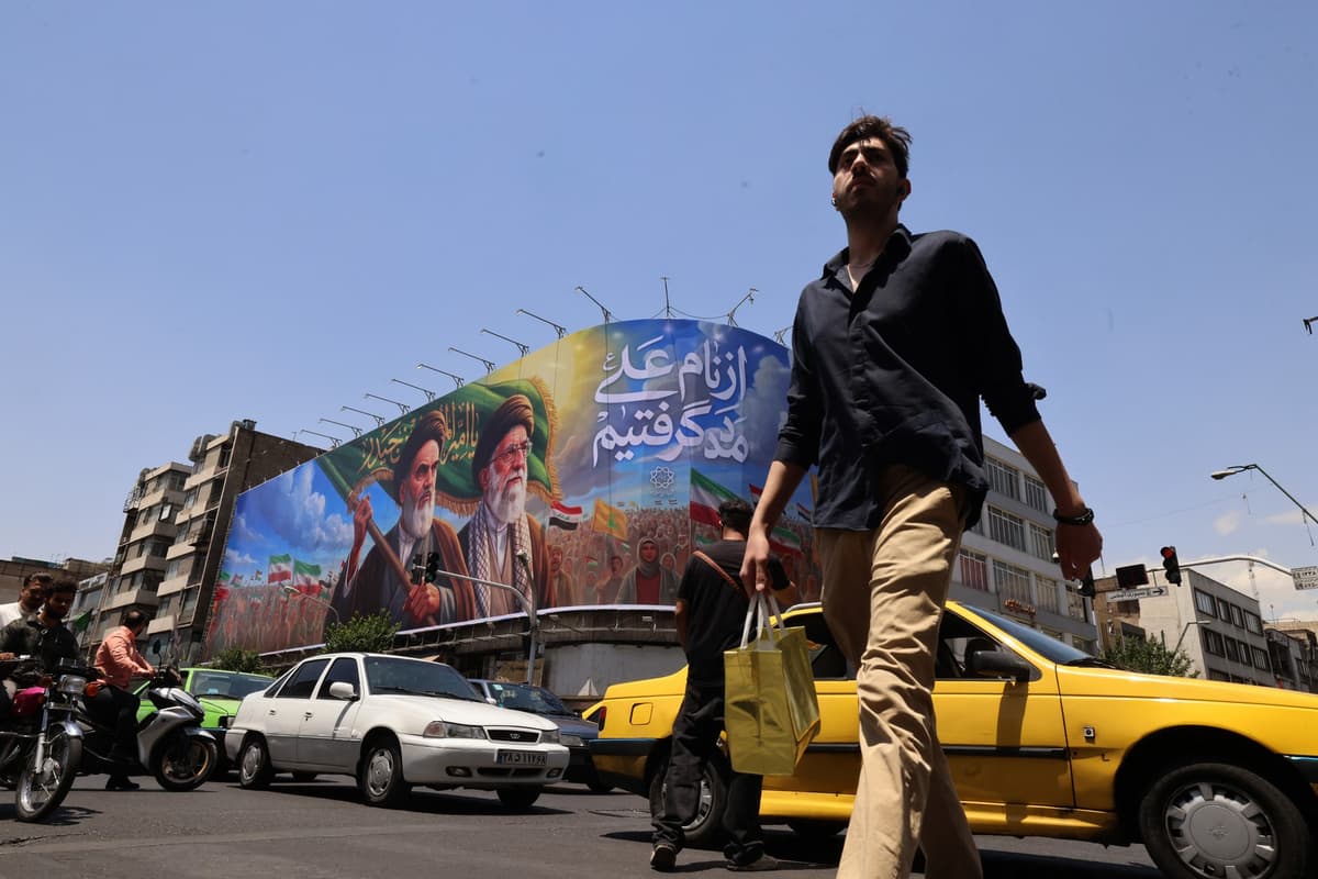Ľudia prechádzajú popri veľkom billboarde s portétmi ajatolláha Ruhollaha Chomejního a zabitého najvyššieho vodcu ajatolláha Alího Chameneího. Foto: ATTA KENARE / AFP / AFP / Profimedia