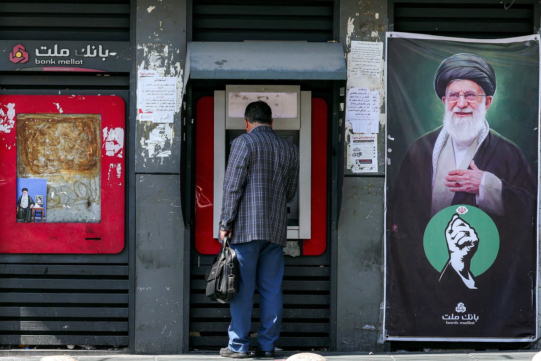 Muž pri bankomate banky Mellat v Teheráne. Foto: AFP / AFP / Profimedia